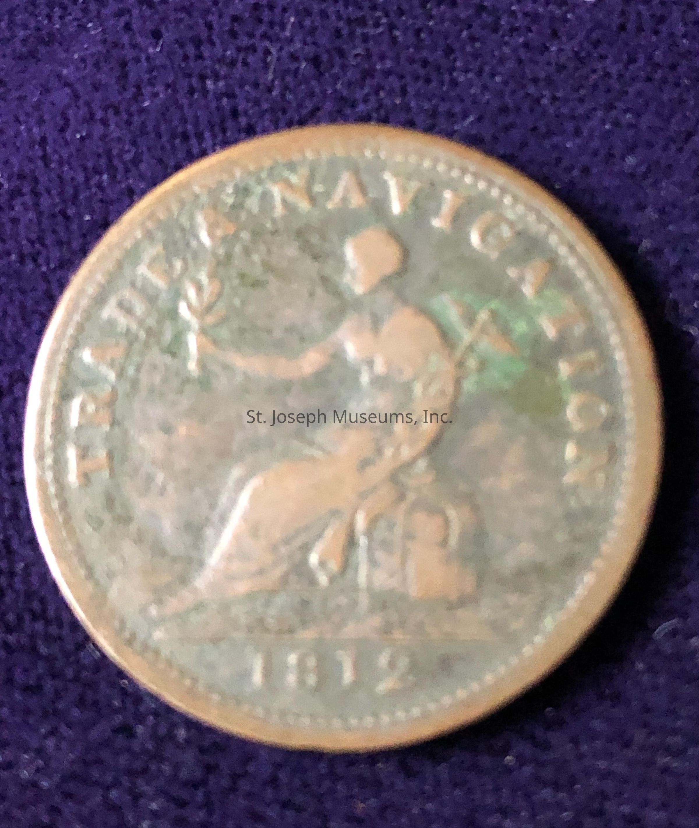 The image shows an old coin from the year 1812, featuring the inscription "TRADE AND NAVIGATION" around the edge. The central design depicts a seated figure holding a trident in one hand, symbolizing maritime strength, and an olive branch in the other, representing peace. This iconic imagery reflects the importance of trade and navigation during the era. The coin appears to be made of metal, with signs of aging, such as tarnish and wear, indicating its historical value and passage through time.