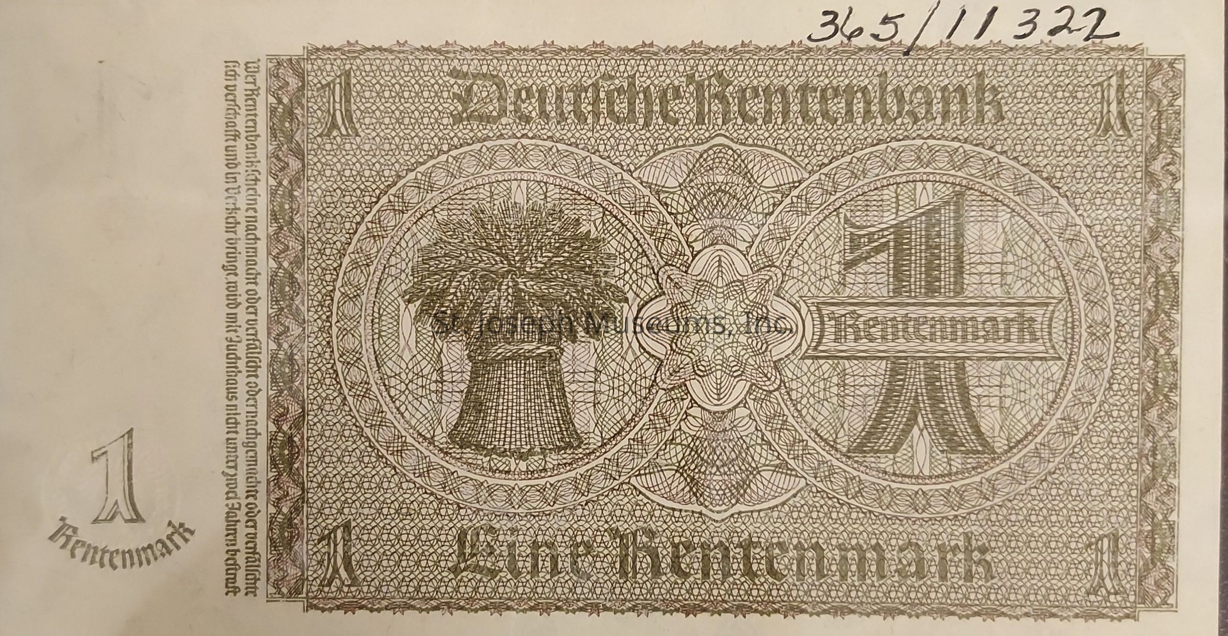 The image depicts an old banknote from the Deutsche Rentenbank, valued at one Rentenmark. The design is intricate, featuring complex patterns and detailed linework. Dominating the center is an image of a sheaf of wheat, symbolizing agriculture and prosperity. The denomination "1 Rentenmark" is prominently displayed in bold, stylized text within a circular motif surrounded by ornate, symmetrical details. The number "1" appears in each corner, reinforcing the note's value, while decorative borders frame the entire banknote. The text running vertically on the left side provides additional information or guidelines about the banknote.