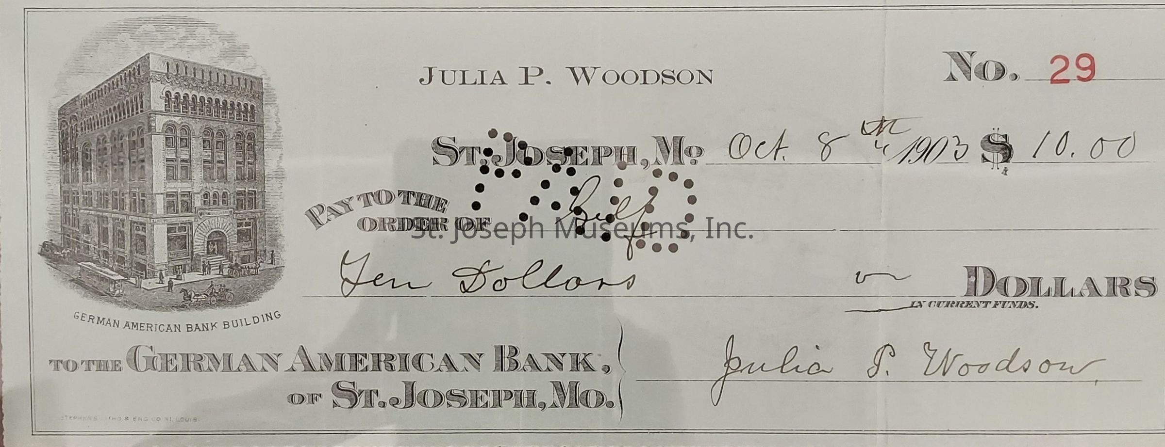 The image displays a vintage check from the early 1900s, specifically dated October 8, 1903, with the amount of $10.00 written in. It is issued by Julia P. Woodson to the order of an unspecified payee. The check is drawn on the German American Bank of St. Joseph, Missouri, and features a detailed illustration of the German American Bank Building. The check number is 29, indicated in red, and it includes decorative typography and a classic design typical of the period, providing a glimpse into the banking and financial practices of that era.