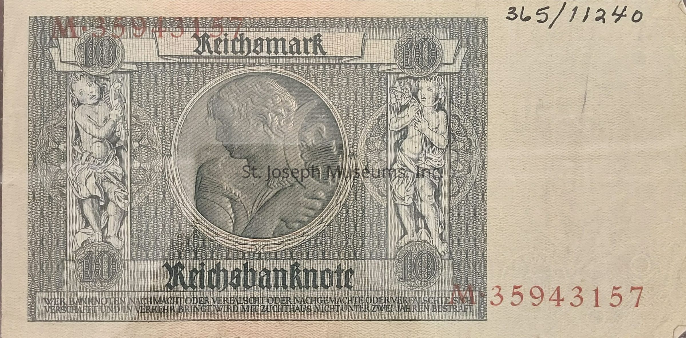 The image is of a historic 10 Reichsmark banknote, which features intricate patterns and designs in shades of grey. In the center, there is a grey circular medallion depicting a classical figure in profile, surrounded by ornate floral and geometric elements. On each side of the medallion, there are cherub-like figures holding floral elements, adding to the elaborate design. The top of the note prominently displays the denomination "10," while the word "Reichsbanknote" is printed below in a gothic font. The serial numbers are printed in red, and there is a handwritten number in black at the top right corner.