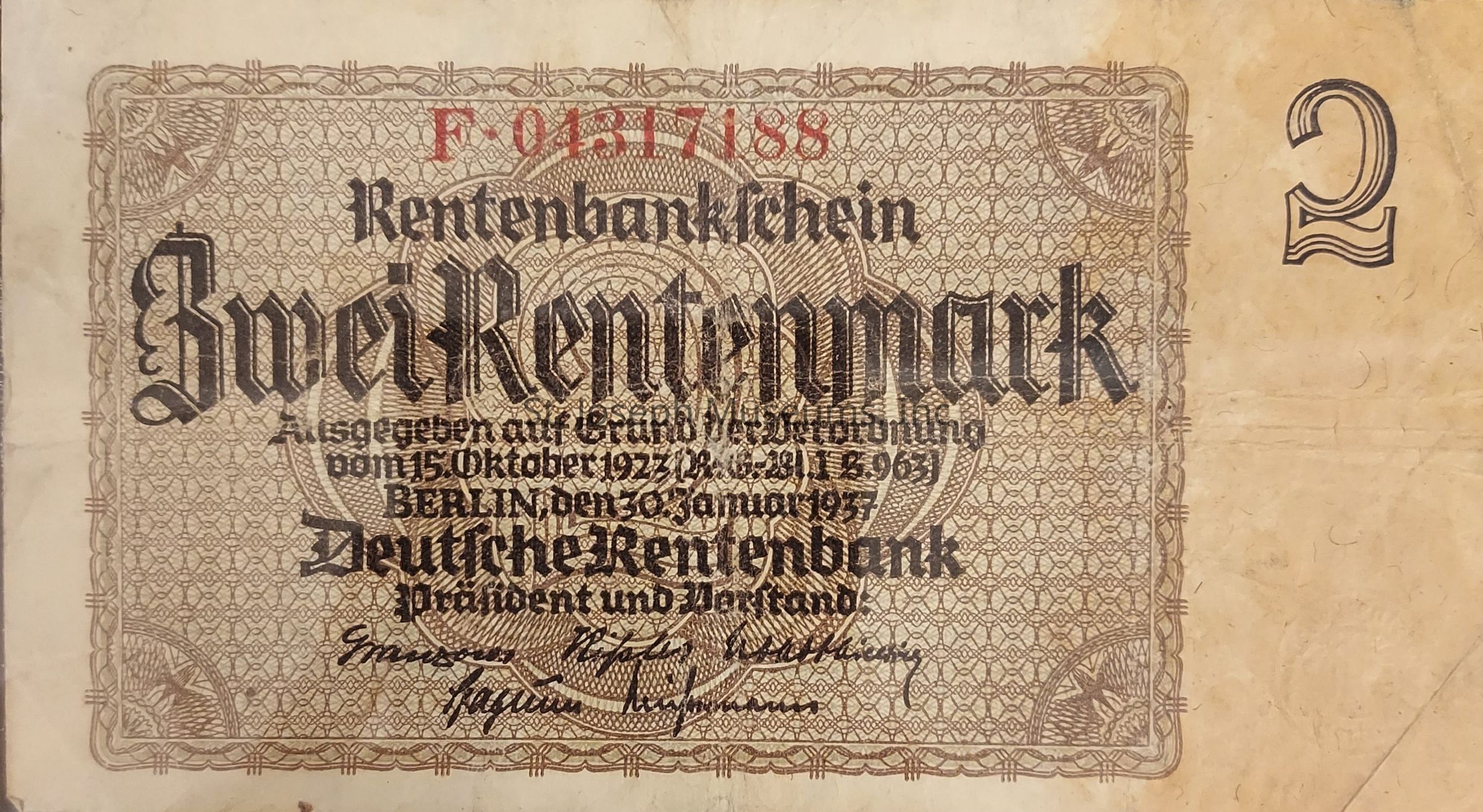 The image depicts an old German banknote with intricate designs featuring a detailed border pattern and the prominent text "Zwei Rentenmark" in a bold, Gothic font, which means "two rentenmark." This banknote was issued by the Deutsche Rentenbank, with visible inscriptions indicating its issue date as based on a decree from October 15, 1923. The note features ornate, decorative elements, consistent with currency design of the early 20th century, providing a glimpse into the economic history of Germany during the post-World War I period. Additionally, it bears signatures and a serial number in red at the top, signifying its authenticity as a legal tender of the time.