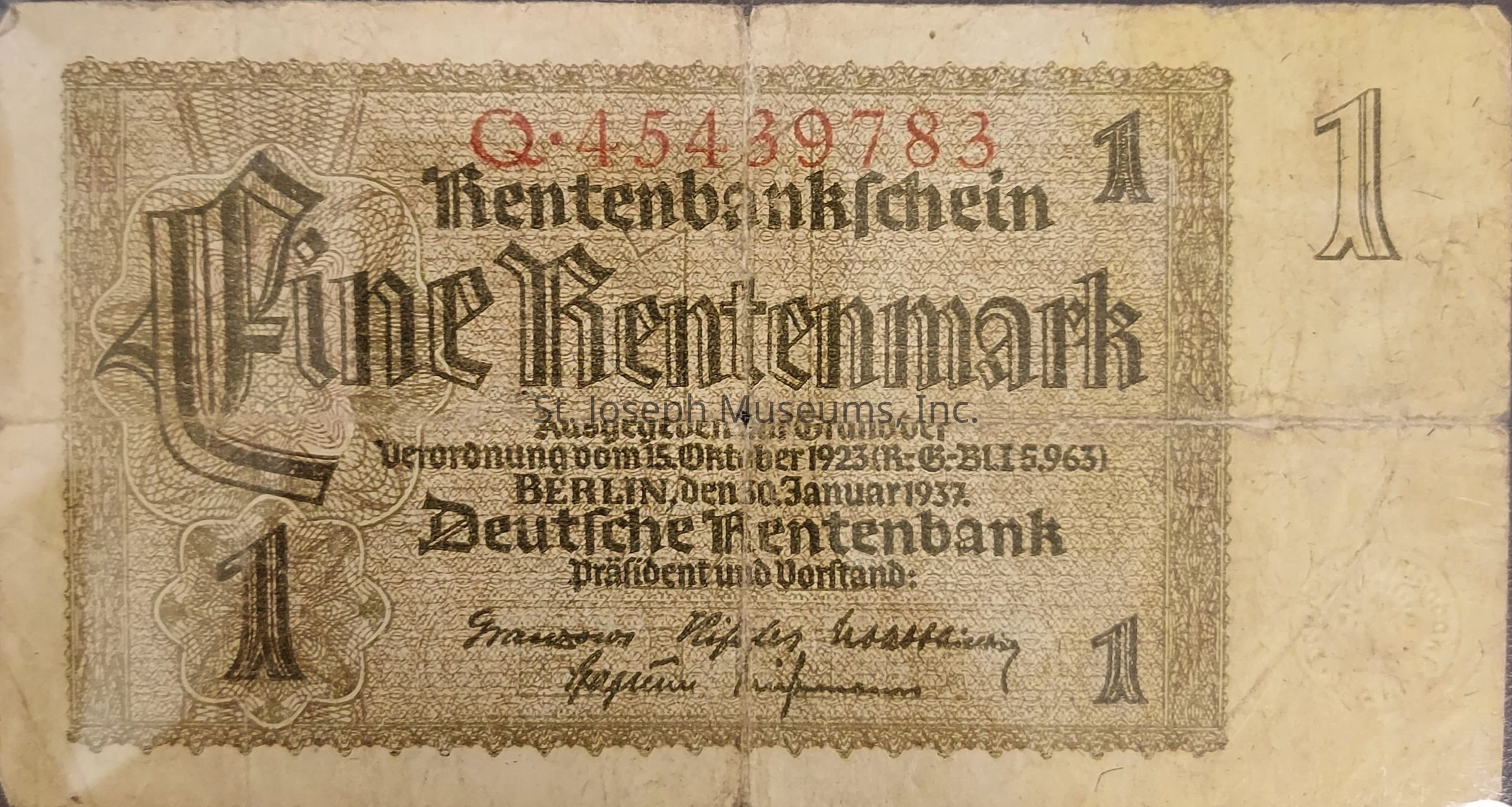 The image shows an old German currency note known as a Rentenmark, specifically a 1 Rentenmark bill, which was introduced in 1923 by the Deutsche Rentenbank as a temporary currency to stabilize the German economy during a period of hyperinflation following World War I. The note features intricate and elaborate patterning around its borders, with the German text prominently displayed in a bold, Gothic typeface. A red serial number is printed at the top, and the denomination "1" appears in each corner. The text includes issuance details, indicating it was printed in Berlin on January 30, 1937, following the regulations of October 15, 1923. The signatures of bank officials are visible at the bottom, and a watermark is faintly discernible. The note's design reflects the historical and economic context of post-war Germany, showcasing both the aesthetic and practical aspects of currency from this period. The paper has visible signs of aging, such as discoloration and cre