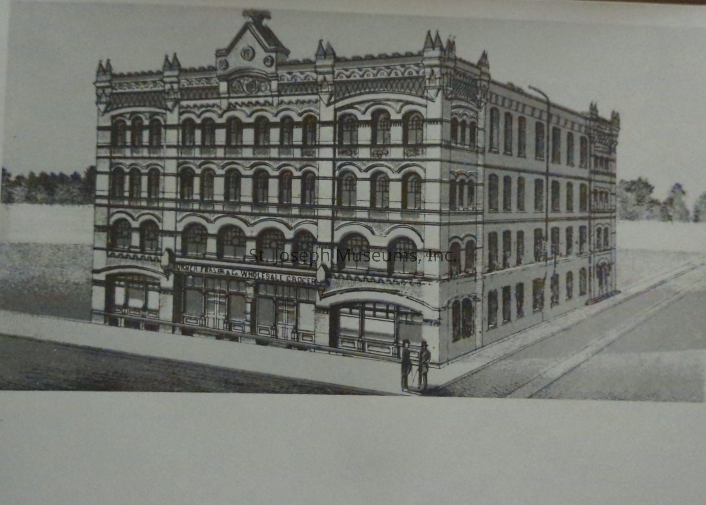 Black-and-white image depicting an artist's drawing of a detailed four-story building located at 302-08 South 3rd Street, identified as Turner-Frazer & Co. Wholesale Grocers. The structure features ornate facade detailing and symmetrical windows, with two figures standing at the entrance, highlighting the building.