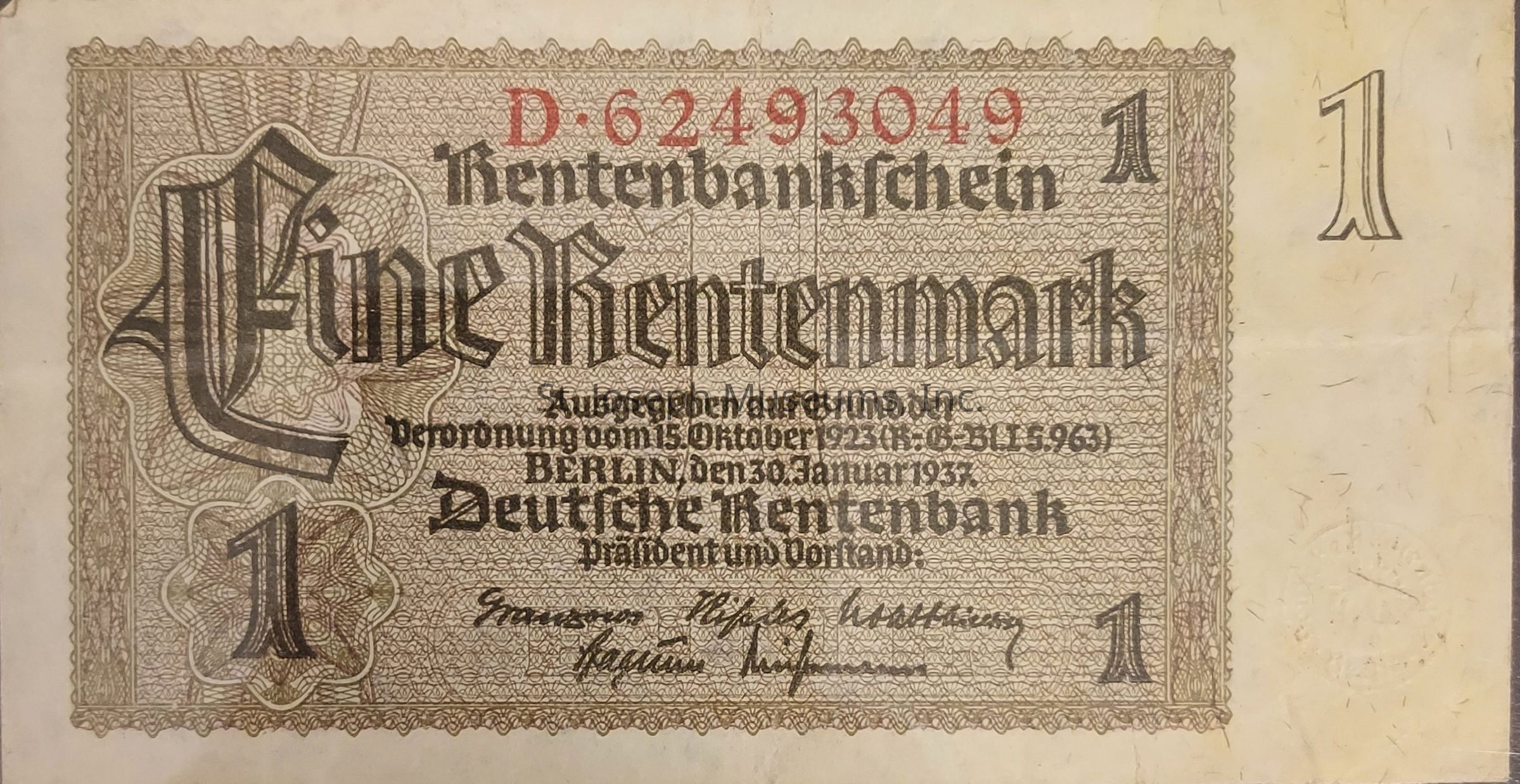 The image displays an old German banknote known as the "Rentenmark," valued at one Rentenmark, with intricate border designs and German Gothic script. At the top, the serial number is prominently printed in red, followed by black text detailing the denomination and bank information. The phrase "Eine Rentenmark" is highlighted in bold, central to the design, while additional text provides the date of issue as January 30, 1937, in Berlin. Signatures appear at the bottom, possibly of bank officials, with ornate patterns filling the background and the number "1" emphasized in the four corners, indicating the denomination.