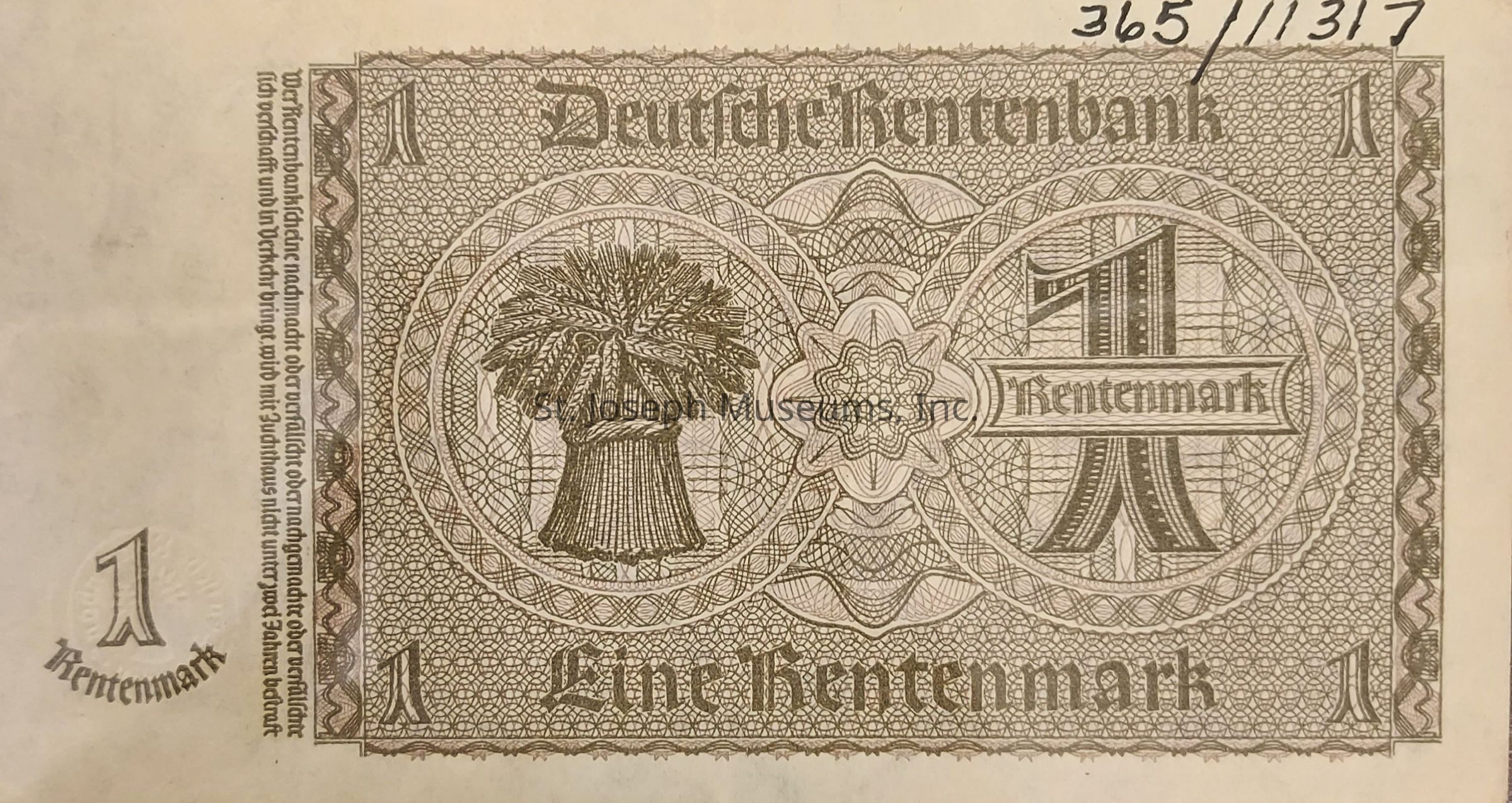 The image depicts an old German banknote with intricate designs and patterns, primarily featuring the denomination of "1 Rentenmark." The center of the note is dominated by an ornate depiction of a sheaf of wheat, symbolizing agriculture or prosperity, encased within a circular design. The surrounding area displays elaborate geometric and guilloche patterns, enhancing the note's aesthetic and authenticity. Along the top and bottom edges, the text "Deutsche Rentenbank" and "Eine Rentenmark" is inscribed in a gothic font, indicating the issuing authority and the currency's value. Additional text runs vertically, likely providing legal or informational context. The top right corner bears handwritten numbers, possibly a serial or identification marker, adding to the note's uniqueness. The overall color scheme is composed of muted browns and beiges, typical of banknotes from this historical period, and the craftsmanship reflects a blend of artistry and security measures characteristic of early 20th-century currency design.