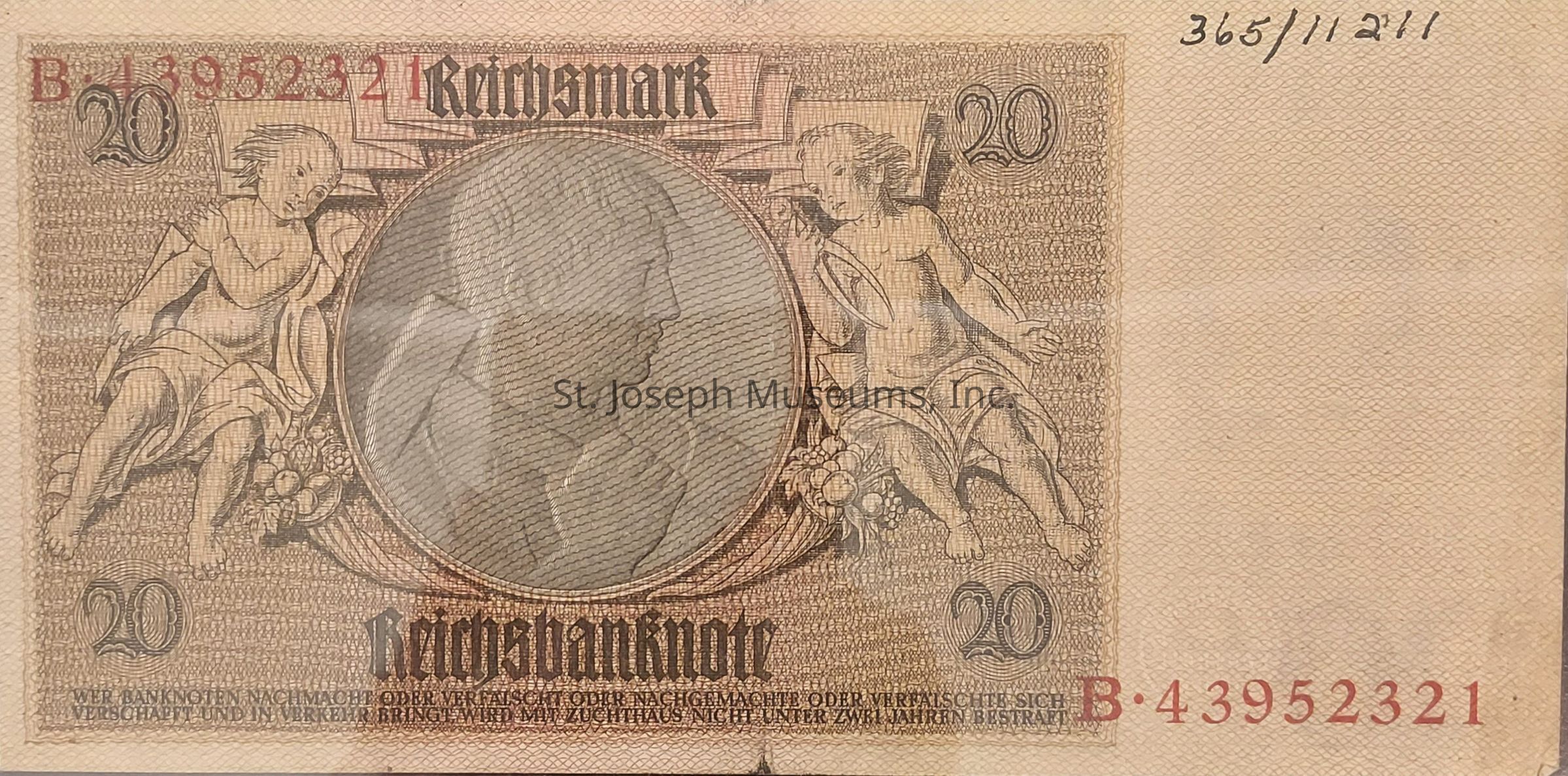 The image depicts a 20 Reichsmark banknote with intricate designs featuring classical figures and floral motifs. The denomination "20" is positioned on the top left and right corners. There is a prominent circular portrait in the center, surrounded by decorative patterns. Above the portrait, the word "Reichsmark" is written in a stylized font, while below, "Reichsbanknote" is printed. Serial numbers are visible in red at the top left and bottom right corners, with smaller printed text at the bottom of the note, providing additional details. The background consists of a fine, detailed pattern.