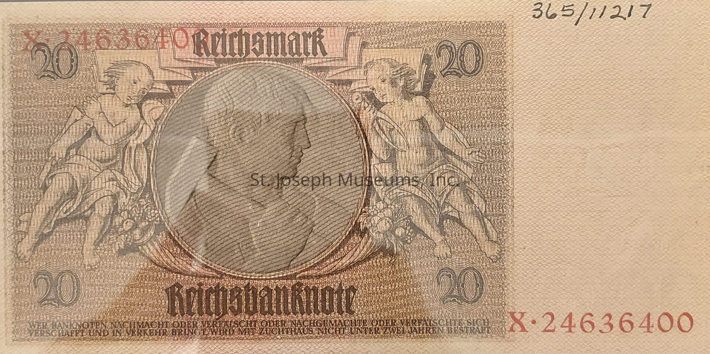 The image displays a 20 Reichsmark banknote featuring intricate artwork, including a central oval portrait and detailed engravings of cherubs on either side. The words “Reichsbanknote” are prominently printed at the bottom, along with legal text warning against counterfeiting. The number "20" appears in all four corners, and a serial number is visible in red at the lower right. The bill's design presents a fine linen-like texture with elaborate patterns, encapsulating a historical aesthetic reminiscent of early 20th-century German currency. The overall color scheme consists of muted browns and tans.