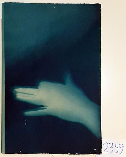 Handmade Dog Cyanotype No. 21 of 32: Norman Durkee, a Seattle composer, was a friend of mine and he sent me a tape of works made on his new Buchla synthesizer. One was titled, "Handmade Dog," a silly, rambling ditty with his synthesized "Woof woof" interspersed. My thought was to collaborate with Norman with my own handmade dogs. I had been doing such hand-shadow prints for some time. The technique, cyanotype, is sometimes called "sun printmaking" because sunlight is ideal, especially in months when the sun is high and rich in UV. The method requires coating paper with chemicals, letting it dry in a dark place, and then - in the sun as I did in this series - laying the paper out flat and putting like one's hand on it. Where the sun strikes the chemical, a reaction occurs and after some seconds or a minute, the paper is shielded until it can be washed. In cold, running water, the unexposed chemicals dissolve and wash away. Where the sun struck, the chemicals became insoluble and turn blue. Invented at the time many photo processes were (the mid-19th Century), it never achieved commercial value except in making blueprints and fine art photographs. To make the series of 32 prints I made a cyanotype or two a day in the summer of 1982, climbing to the rooftop hatch to the top of the Journal of Commerce Building in Seattle, which was home to the Triangle Studios for me from 1977-1983. See my memoir, "Dumb Hope: My curious life - 1981-1990."