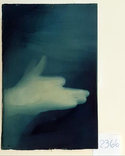 Handmade Dog Cyanotype No. 28 of 32: Norman Durkee, a Seattle composer, was a friend of mine and he sent me a tape of works made on his new Buchla synthesizer. One was titled, "Handmade Dog," a silly, rambling ditty with his synthesized "Woof woof" interspersed. My thought was to collaborate with Norman with my own handmade dogs. I had been doing such hand-shadow prints for some time. The technique, cyanotype, is sometimes called "sun printmaking" because sunlight is ideal, especially in months when the sun is high and rich in UV. The method requires coating paper with chemicals, letting it dry in a dark place, and then - in the sun as I did in this series - laying the paper out flat and putting like one's hand on it. Where the sun strikes the chemical, a reaction occurs and after some seconds or a minute, the paper is shielded until it can be washed. In cold, running water, the unexposed chemicals dissolve and wash away. Where the sun struck, the chemicals became insoluble and turn blue. Invented at the time many photo processes were (the mid-19th Century), it never achieved commercial value except in making blueprints and fine art photographs. To make the series of 32 prints I made a cyanotype or two a day in the summer of 1982, climbing to the rooftop hatch to the top of the Journal of Commerce Building in Seattle, which was home to the Triangle Studios for me from 1977-1983. See my memoir, "Dumb Hope: My curious life - 1981-1990."