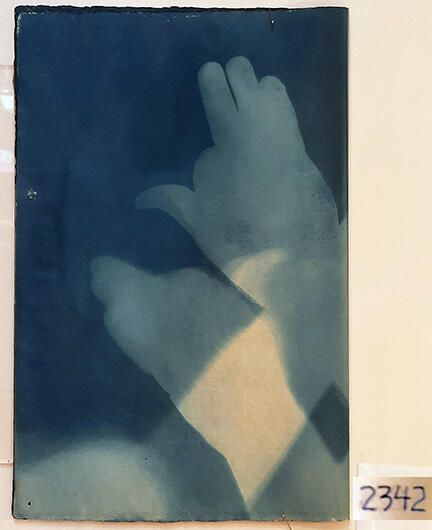 Handmade Dog Cyanotype No. 4 of 32: Norman Durkee, a Seattle composer, was a friend of mine and he sent me a tape of works made on his new Buchla synthesizer. One was titled, "Handmade Dog," a silly, rambling ditty with his synthesized "Woof woof" interspersed. My thought was to collaborate with Norman with my own handmade dogs. I had been doing such hand-shadow prints for some time. The technique, cyanotype, is sometimes called "sun printmaking" because sunlight is ideal, especially in months when the sun is high and rich in UV. The method requires coating paper with chemicals, letting it dry in a dark place, and then - in the sun as I did in this series - laying the paper out flat and putting like one's hand on it. Where the sun strikes the chemical, a reaction occurs and after some seconds or a minute, the paper is shielded until it can be washed. In cold, running water, the unexposed chemicals dissolve and wash away. Where the sun struck, the chemicals became insoluble and turn blue. Invented at the time many photo processes were (the mid-19th Century), it never achieved commercial value except in making blueprints and fine art photographs. To make the series of 32 prints I made a cyanotype or two a day in the summer of 1982, climbing to the rooftop hatch to the top of the Journal of Commerce Building in Seattle, which was home to the Triangle Studios for me from 1977-1983. See my memoir, "Dumb Hope: My curious life - 1981-1990."