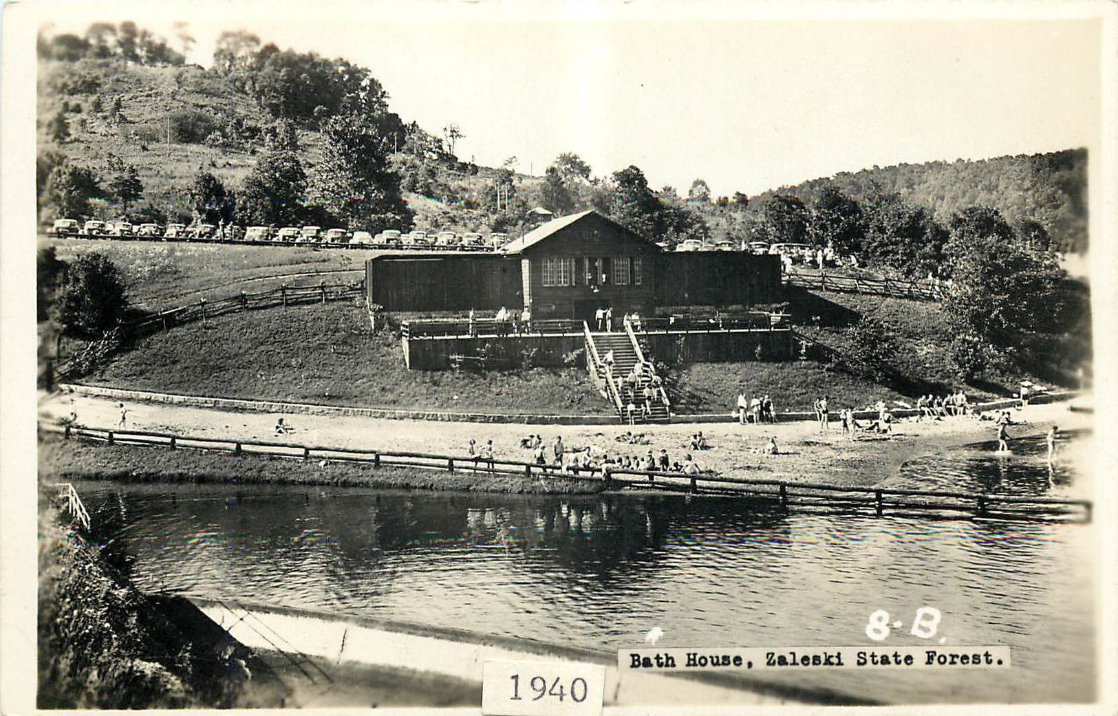Lake Hope State Park - Bathhouse and Swimming Beach, 1940: Lake Hope's bathhouse and swimming beach on a busy summer day in 1940. Note the vehicles crowding the parking lot behind the bathhouse. Generations of Ohioans have spent relaxing afternoons at Lake Hope even before it became a state park in 1949. All of Lake Hope State Park was once part of the Zaleski State Forest. Today, the Zaleski State Forest surrounds Lake Hope State Park.