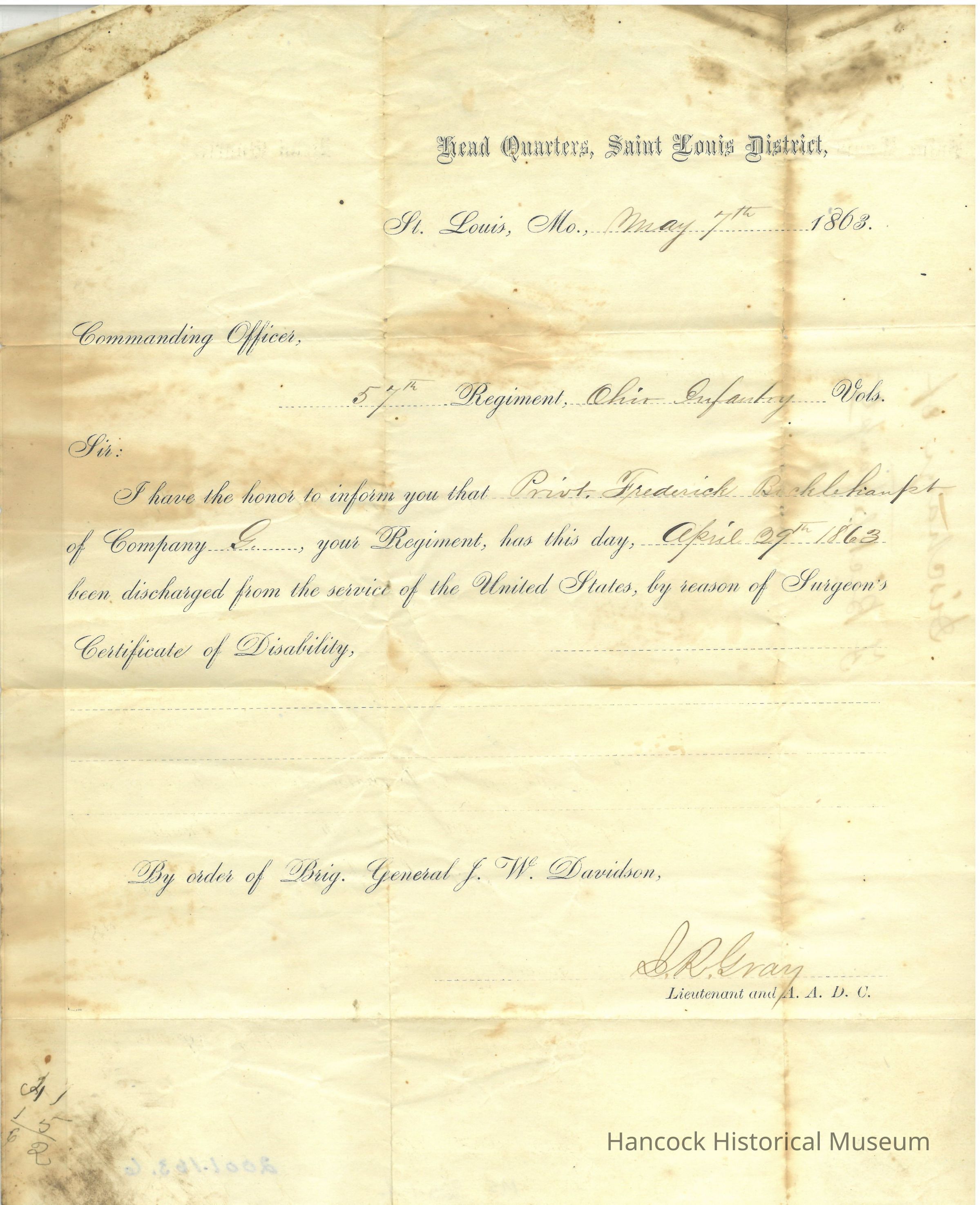 The image displays an official-looking, aged document titled "Head Quarters, Saint Louis District," dated May 7, 1863, from St. Louis, Mo. The letter is addressed to the Commanding Officer of the 27th Regiment, Ohio Infantry Volunteers. It notifies the officer that Private Frederick Robelshamft of Company C has been discharged from the service of the United States on April 29, 1863, based on a Surgeon’s Certificate of Disability. The document is signed by a Lieutenant and A.A.D.C. named S. M. Gray, with the order coming from Brigadier General J.W. Davidson. The document possesses notable stains and folds indicative of its age, presenting a distinctive vintage appearance.