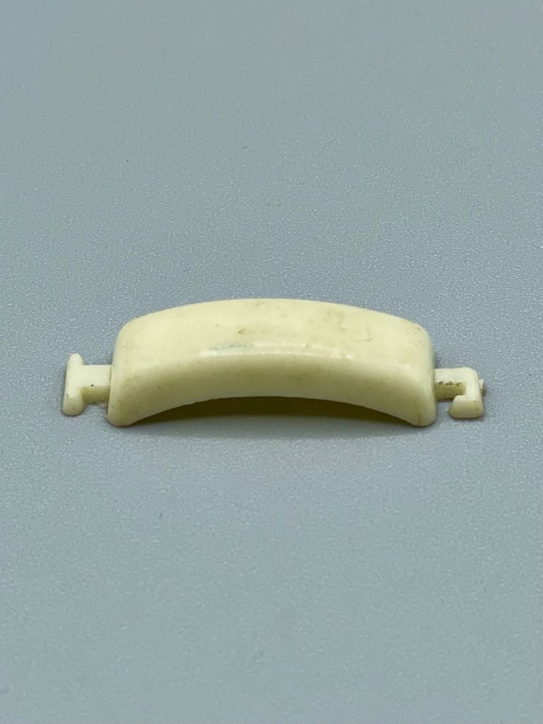 Curved cream plastic hair-tie bar (ponytail holder), elastic band absent