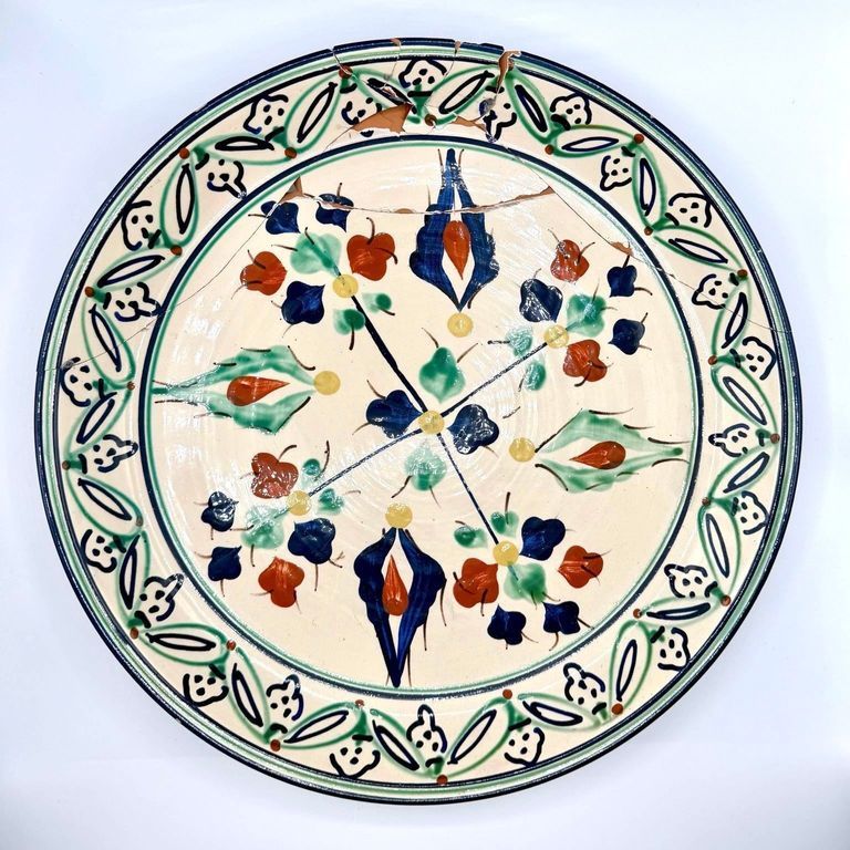 Hand-painted decorative earthenware plate, repaired