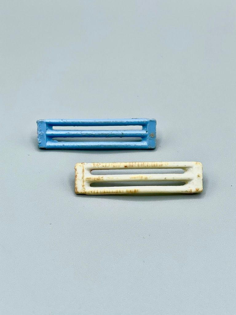 Pair of barrette clip-bodies (arched slotted bars, hinge pin/spring missing)