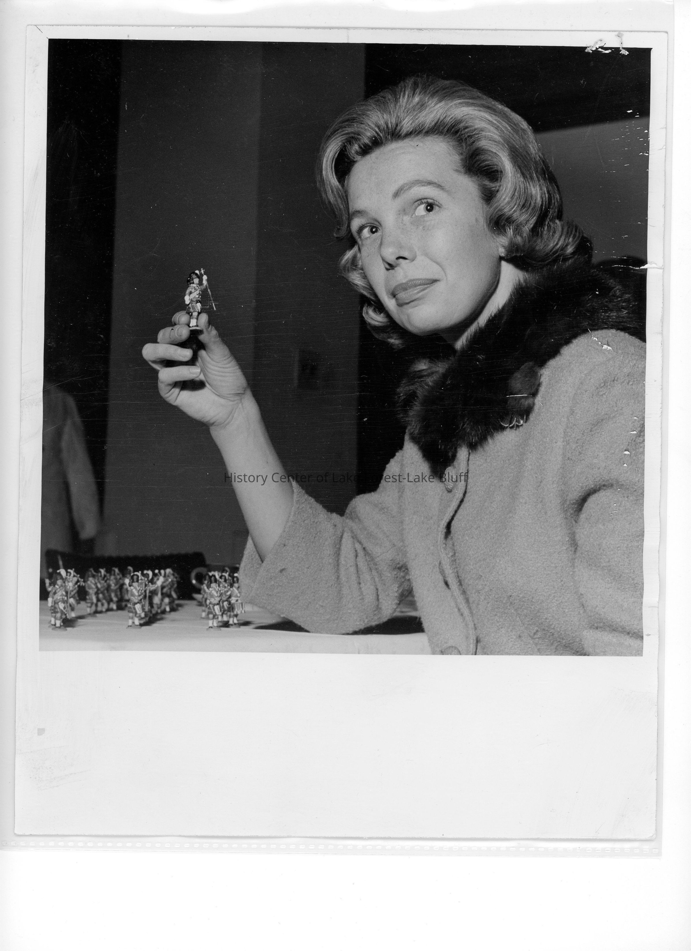 "Showing miniature replica of a Royal Marine, Britain's 'sea soldier,' is Mrs. Frank. A Priebe Jr., president of the Lake Forest Center of Infant Welfare. The Royal Marines Tattoo will perform here Dec. 12 sponsored by the center, and on Dec. 11, for Hadley School for the Blind." Credit: Chicago Daily News, Dec. 9, 1964.