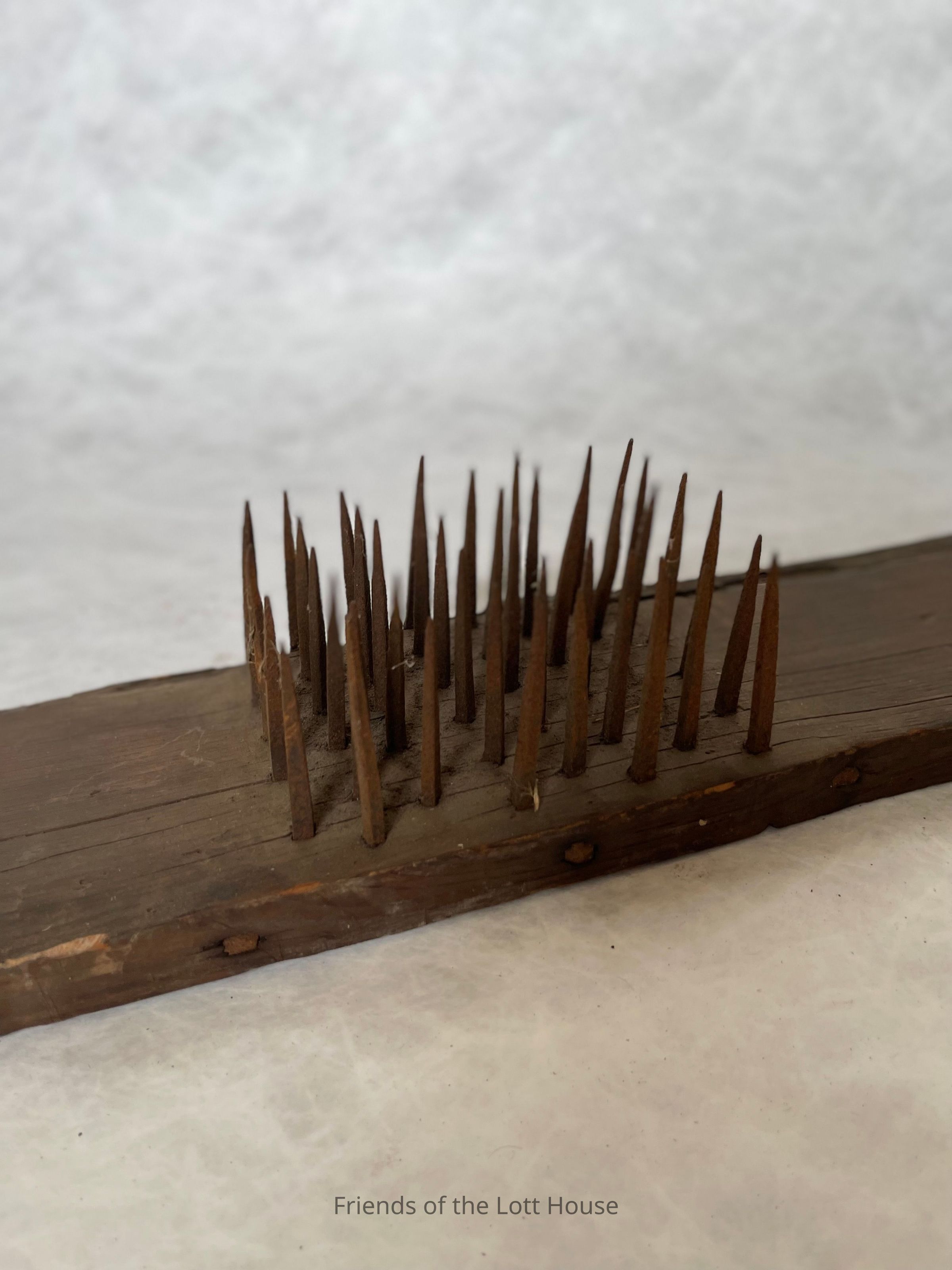 Combing wool would have been a regular and essential job on a farm that produced textiles. Workers carefully separated the wool into different layers using a wool comb, like the one pictured here. After shearing sheep or other animals, they sorted the wool to remove the undercoat from the coarser outer coat. This process helped prepare the fibers for spinning into yarn, which could be woven into fabric or used for knitting. The wool combs helped untangle, straighten, and clean the fibers, preparing them for the next stages of textile production.
Combing wool was not just about separating fibers; it was also about improving the quality of the finished product. If workers did not comb the wool properly, they could create uneven or coarse yarn, which would affect the overall quality of the fabric. By using the combs, farmers could produce clean, smooth fibers that would spin into strong, durable yarn, which they could then turn into everything from clothing to blankets. The wool combs themselves came in various sizes. Smaller, handheld versions were helpful for smaller amounts of wool, often used in homes for personal textile production.