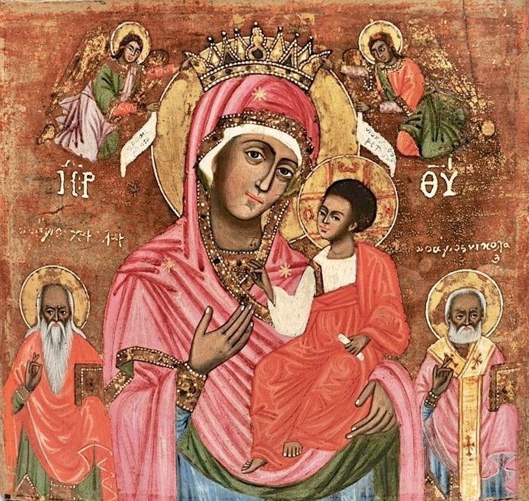 An icon a central figure of a crowned Virgin Mary, dressed in a pink robe and holding Jesus, who is in a matching robe while sitting on her lap; the background is rich with gold hues, surrounded by additional figures of saints, rendered in vibrant colors with golden halos that highlight their significance and holiness, reflecting the iconographic style rooted in Byzantine traditions, but rendered in Greece or Cyprus