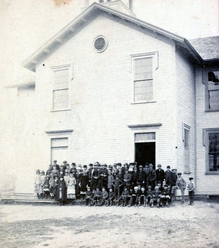          Students at the Dennysville Town School, c. 1910; Elementary and high school students gathered with their teachers on the front steps of the Dennysville Town School around 1910.  The primary school students, in front, were taught in one downstairs classroom, while the high school students received instruction in the other.  Judging from the caps and warm cloaks, the photograph must have been taken on a cold day.  The school bell visible in the belfry above was relocated to the lawn of the Lincoln Memorial Library next door when the schoolhouse was demolished in 1964.
   