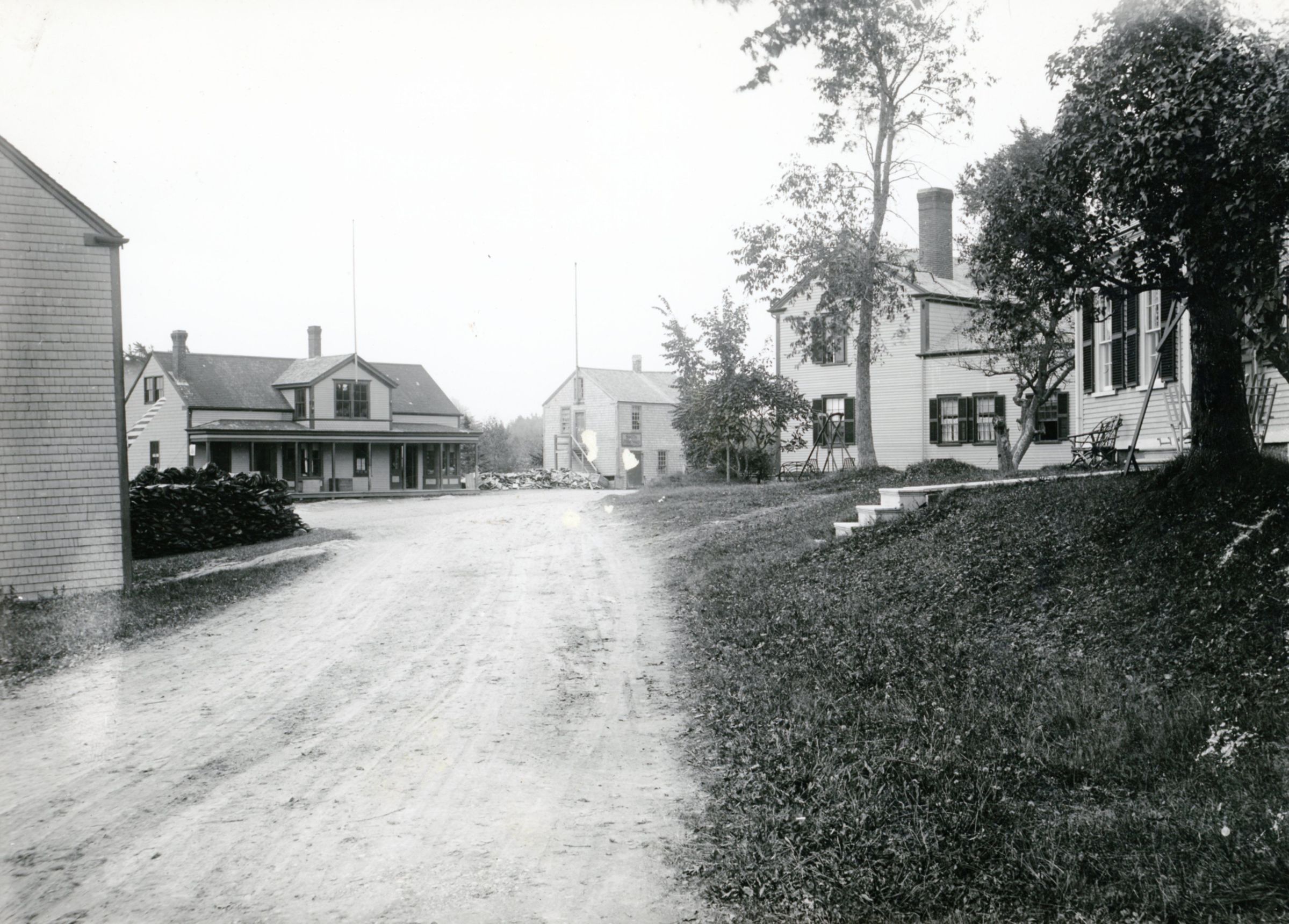 Store Hill After 1909, Dennysville, Maine; Store and G. A. R. Hall across the street, Howard Laughton's barber shop on left, and Benjamin Foster's and Will Allan's houses on right.