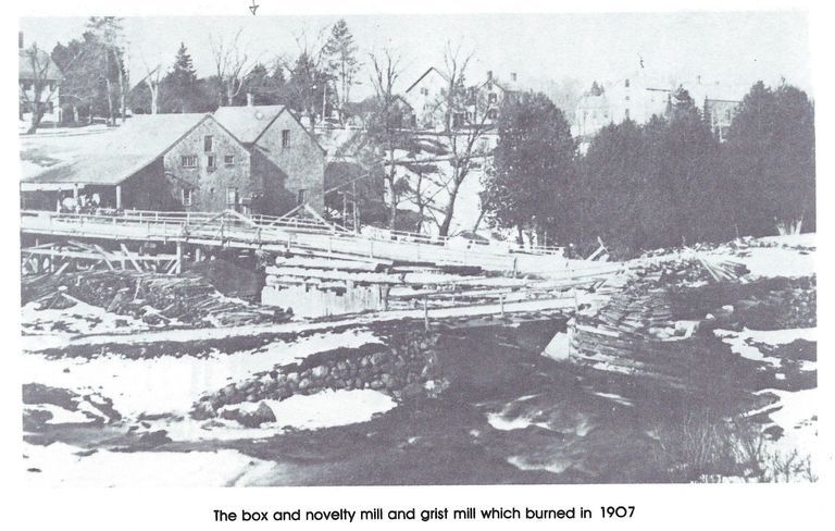          The Box and Novelty Mill and Grist Mill on the Dennys River, c. 1905; Water swirls under the Upper Bridge with the box and grist mills built by T.W. Allan on the far side of the Dennys River.   Photograph reproduced from Rebecca W. Hobart, Dennysville 1786-1986 . . . and Edmunds, Too!
   