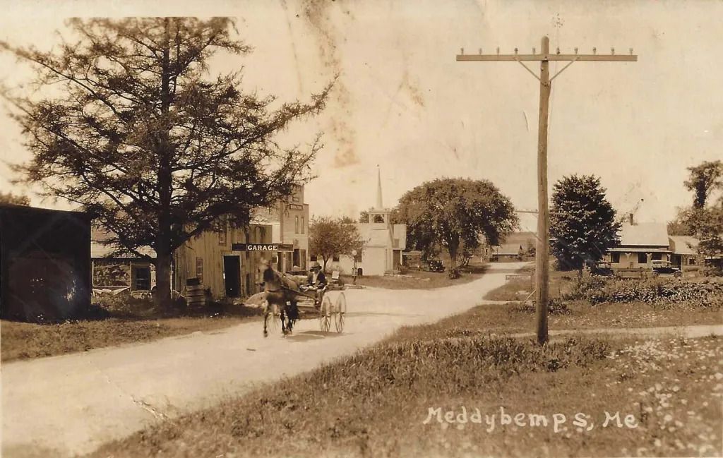 Main Street in Meddybemps; View down Main street in Meddybemps, Maine with horse and buggy, businesses and Church building in the distance, c. 1900.