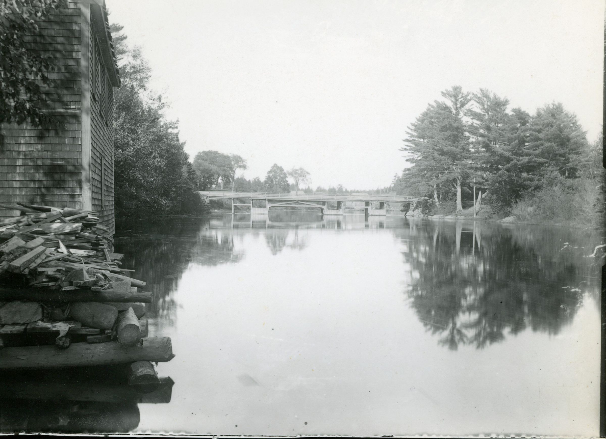 Lower Bridge over the Dennys River, Dennysville, Maine; Photograph of the Lower Bridge as seen upriver from Gardner's Store, in Dennysville, Maine. Image from the Hallowell Collection courtesy of the Tides Institute in Eastport, Maine.