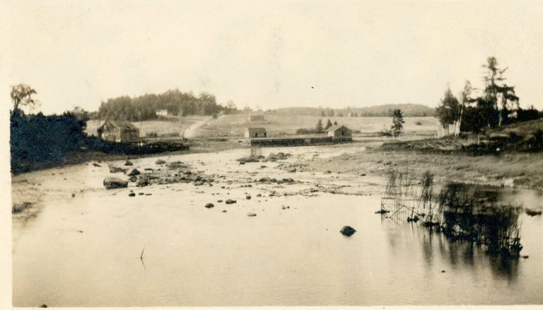          Fish Weir on the Dennys River; View of a fish weir on the Dennys River at low tide, with the Lincoln Dock, Wharf and Corn Hill in the background in the latter half of the nineteenth century.
   