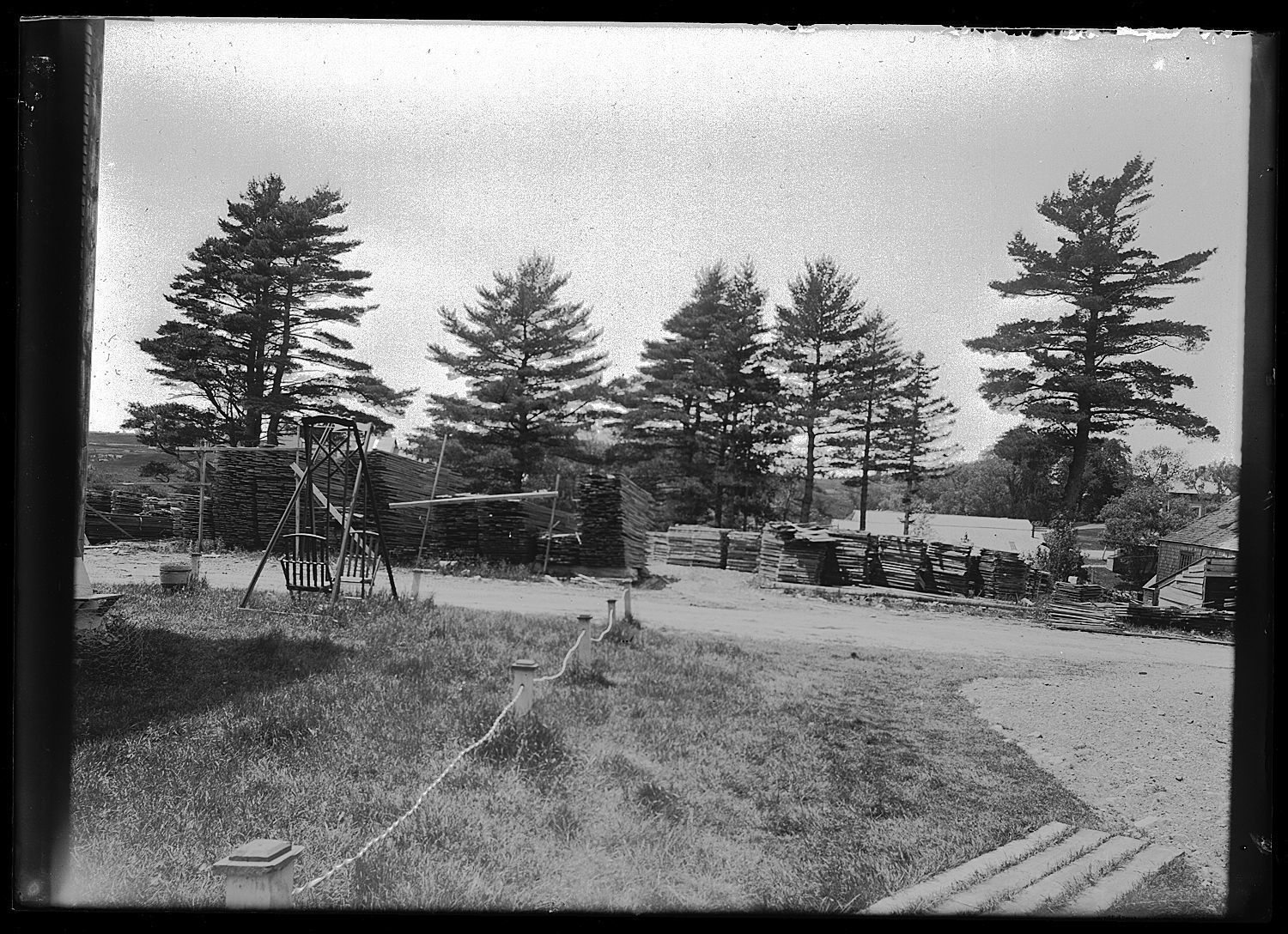 Long lumber drying near the Lincoln Mills on the Dennys River; Long lumber is stacked to before shipment on the banks of the Denys River, as seen from the boarding house on the Bunker Hill Road in Edmunds, Maine.