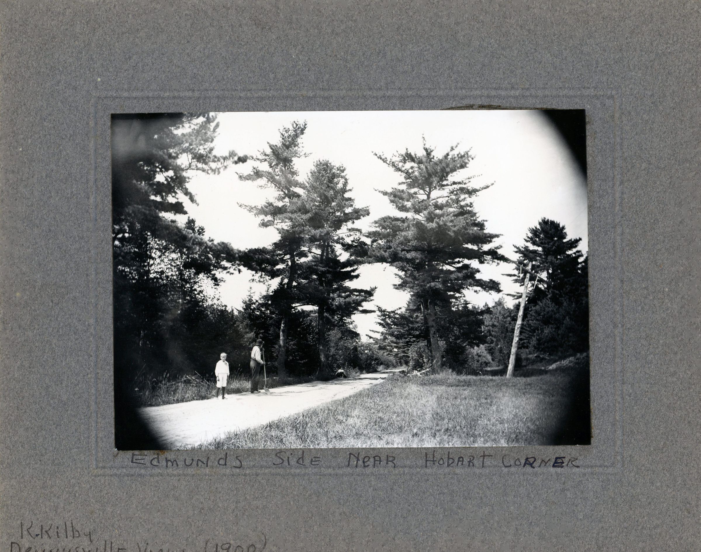 River Road Near Hobart Corner, Edmunds, Maine; A view of the River Road in front of the house of John P. Sheahan, in Edmunds, Maine. A child is standing near several men working on the road. Photo courtesy of The Tides Institute, Eastport, Maine, with a caption by Keith Kilby.