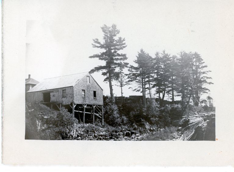          Bucket Factory and Pail Mill, Edmunds, Maine, c. 1880; A bucket factory was located on the Edmunds side of the Dennys River, just below the Lincoln's mill dam.  Marked on the 1861 map of the Dennysville Village, it has disappeared by 1881, replaced by machine shop.  The roof of the mill worker's boarding house is visible above the roofline of the factory building, and the famous State Seal pines are located beside it.  Photo Courtesy of The Tides Institute, Eastport, Maine
   