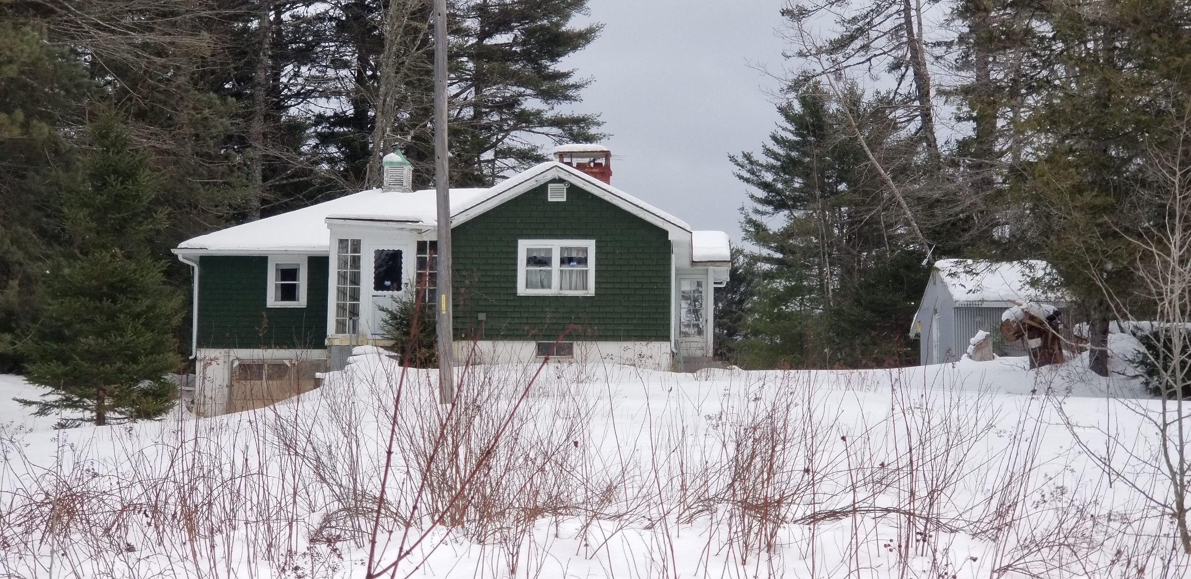 Green House on Rte. 86, Marion, Maine near Katie Maker's Corner.; A snug green house of modern design rests under a blanket of snow on a cold winter's day in Marion.