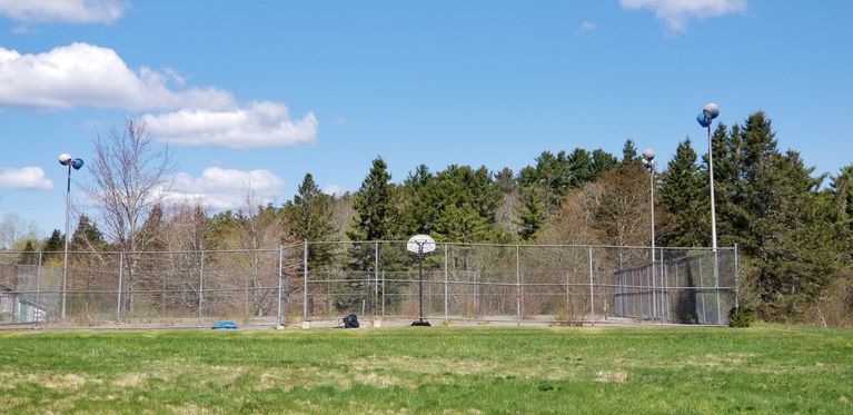          Tennis Courts on The Lane, Dennysville, Maine.; Currently disused tennis courts on The Lane provide a space for basketball practice.
   