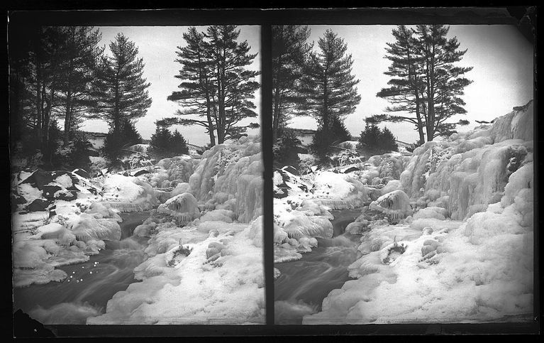          Mill Pond Dam on the Dennys River in Winter.; Water percolates through the ice coated mill dam on the Dennys River in this photograph by Edmunds photographer Dr. John P. Sheahan, c. 1885.
   