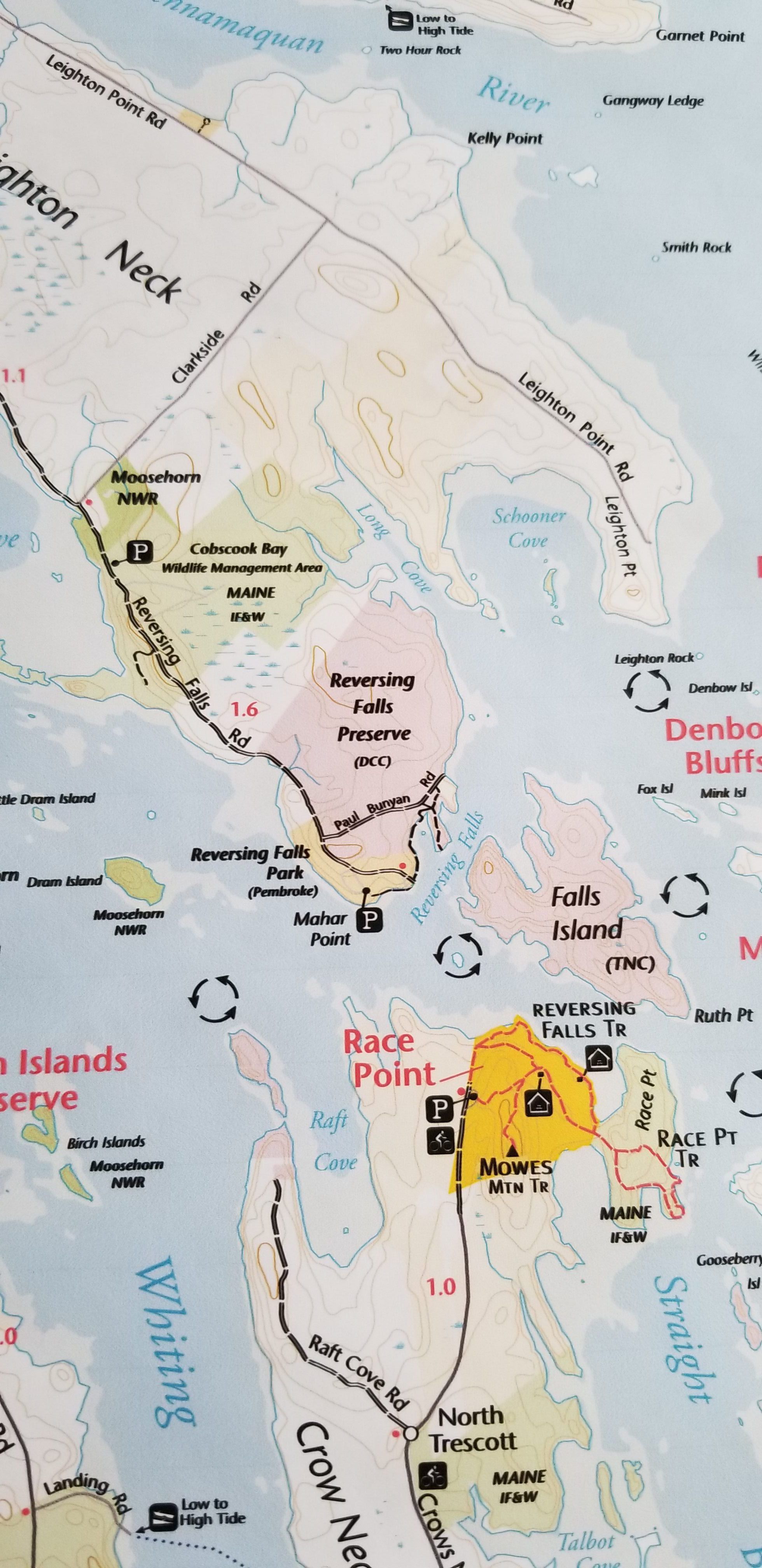 Conservation Land on the tip of Leighton's Neck in Pembroke, Maine, in 2022; A checkerboard of land under conservation management around the Reversing Falls on Leighton's Point Pembroke and Crow Neck, Trescott, Maine. These include the Moosehorn National Wildlife Refuge (NWR), Maine Department of Inland Fisheries and Wildlife (IF&W), Downeast Coastal Conservancy (DCC), The Nature Conservancy (TNC), Cobscook Shores Foundation, and the Town of Pembroke. This detail is from a larger trail map of the area prepared by the Cobscook Shores Foundation in 2022.