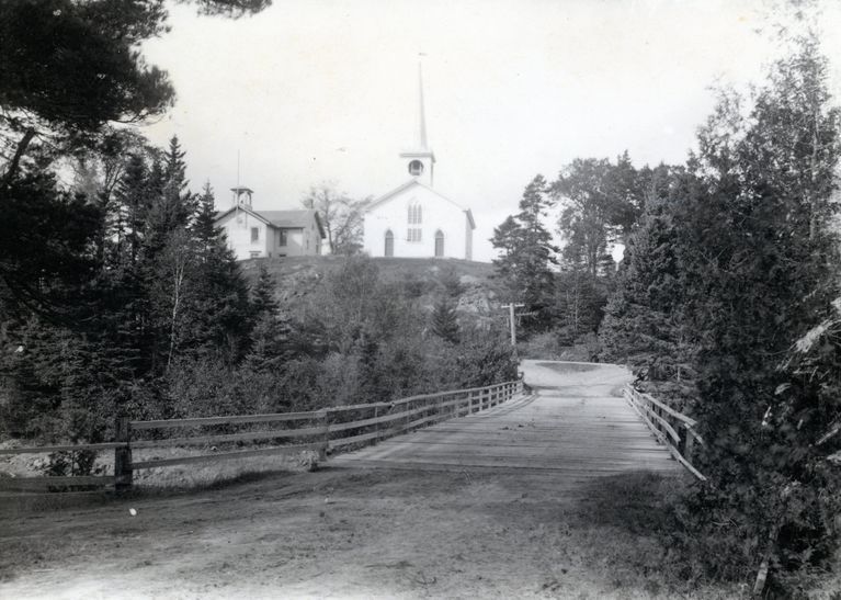          View of Lower Bridge Between Edmunds and Dennysville, c. 1910; The Congregational Meetinghouse and schoolhouse in Dennysville are seen above the Lower Bridge on Meetinghouse Hill
   